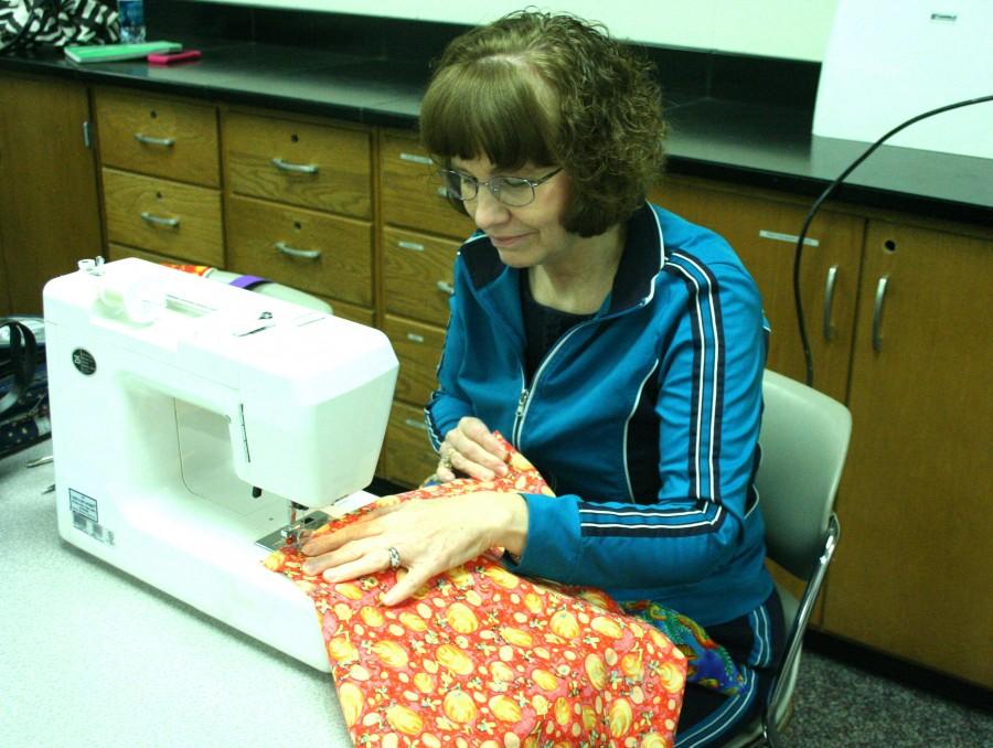 Janet Arnold, lecturer of mathematics, sews a dress for the organization “Little Dresses for Africa” on March 11 in the basement of the Physical Sciences Building. Photo by Courtney McKinley.