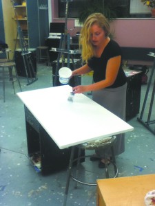 Alyssa Hubbard, fine arts senior, adds gesso layers to a painting canvas to prevent damage from paint oils.