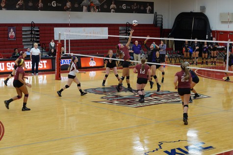 Junior outside hitter, Katie Fischer attempts to spike the ball on the St. Catharine front line.