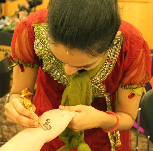 Ishwarya Iyer, adjunct professor of social informatics, tattoos henna at International Festival 