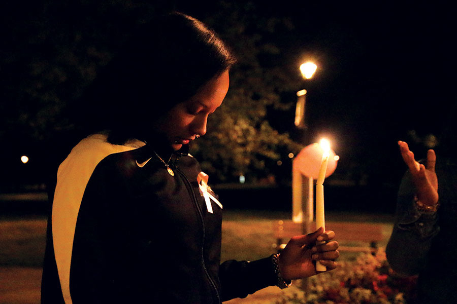 Francesca Komora, sociology junior, holding a candle while they say a prayer at the beginning.
