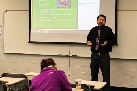 Seuth Chaleunphonh presents a lecture on alcohol education to a student on Friday, Feb. 12.