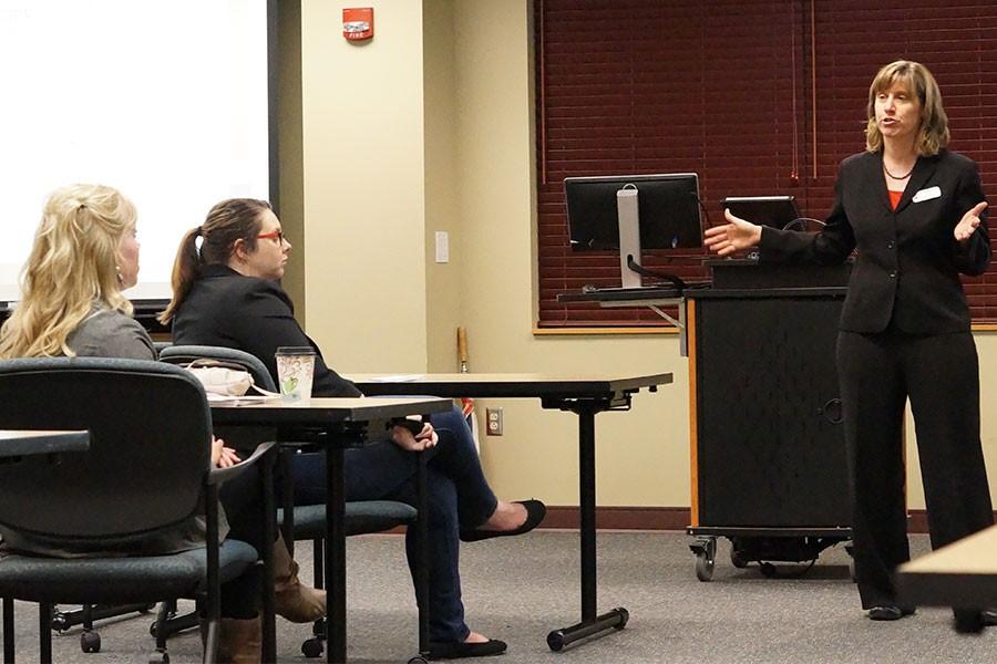 Melissa Fry, assistant professor of sociology and director of the Applied Research and Education Center at IU Southeast, tells a story about one of her clients who lost everything as Annell Lough, outreach advisor for the Center for Women and Families, and another attendee listen.
