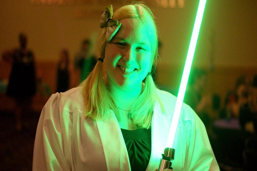Cendra Stacey, criminal justice and psychology senior, president of the Asian Pop Culture Club and cosponsor of the Spring Ball, dresses as Yoda and holds a green lightsaber in one hand.
