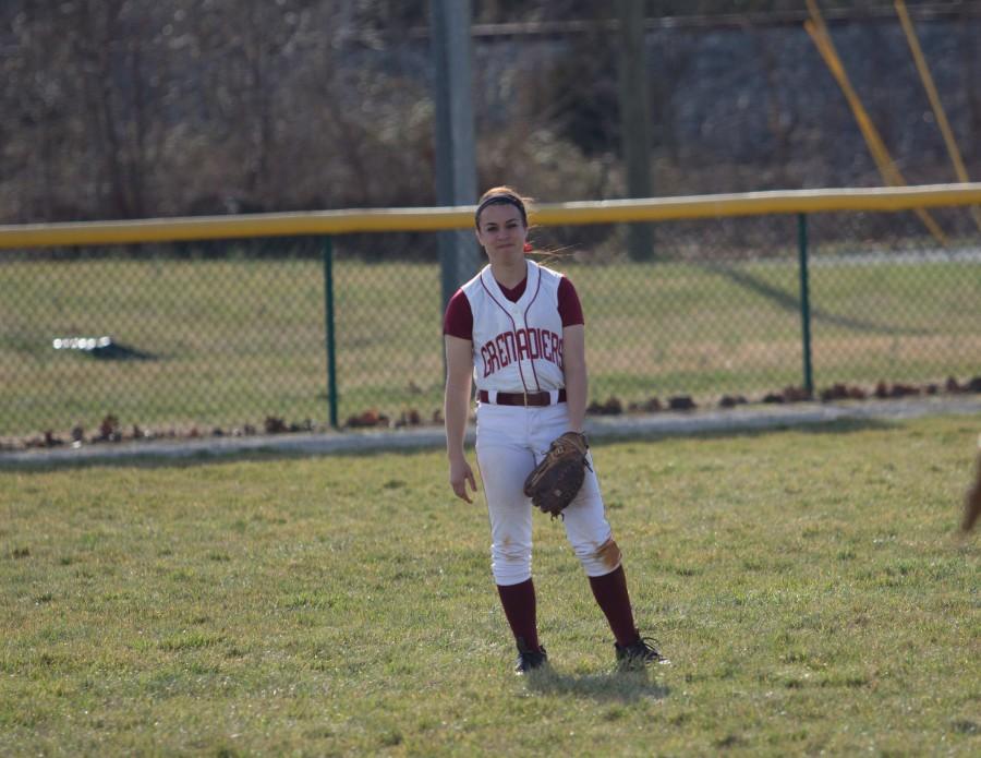 Junior outfielder Brooke Barnett warming up between innings.