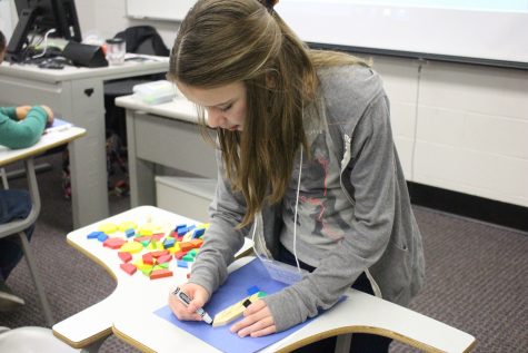 A student working on geography by tracing blocks.