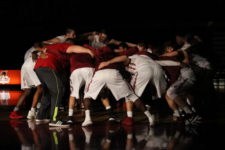 The men’s basketball team gathers for a pre-game huddle.