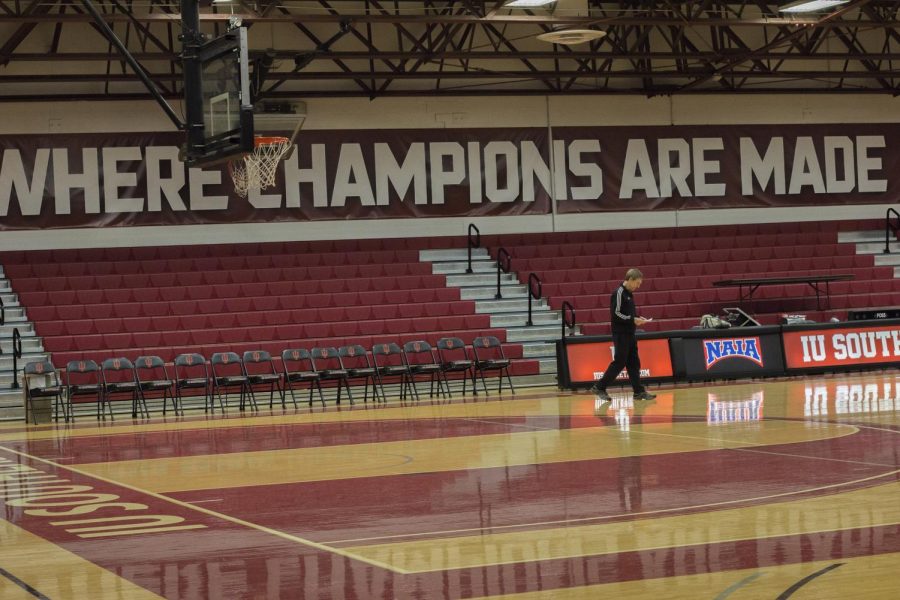 Coach Robin Farris, the newest member of the NAIA Division II 500 win club, reviews his notes for practice before the Grenadiers take the floor