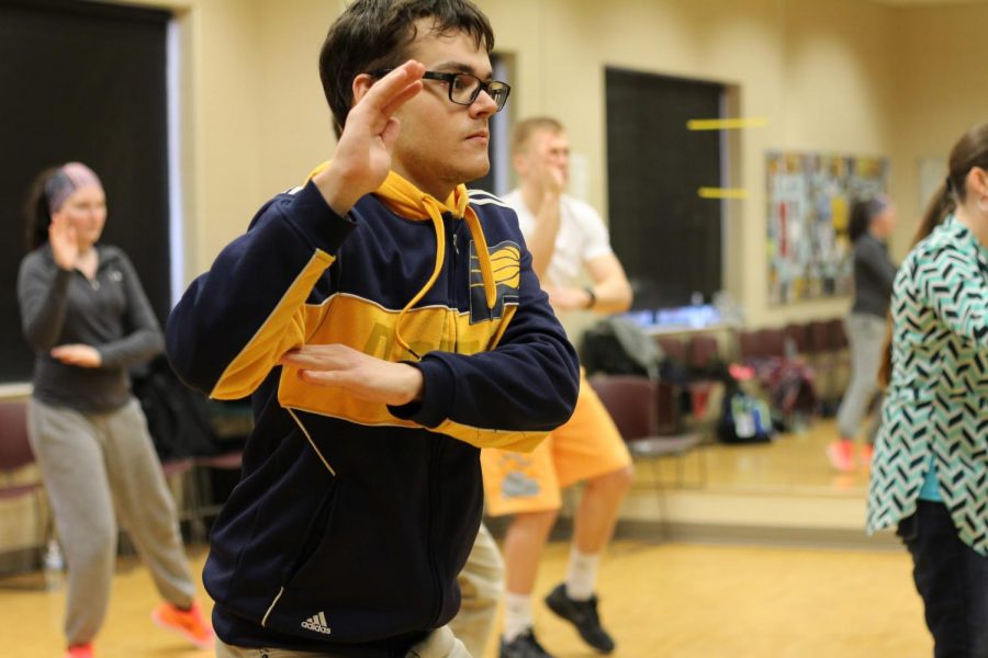 Max Thieman, IU Southeast student currently taking Tai-chi Basics, warms up with a move called “Hands in the Clouds.”