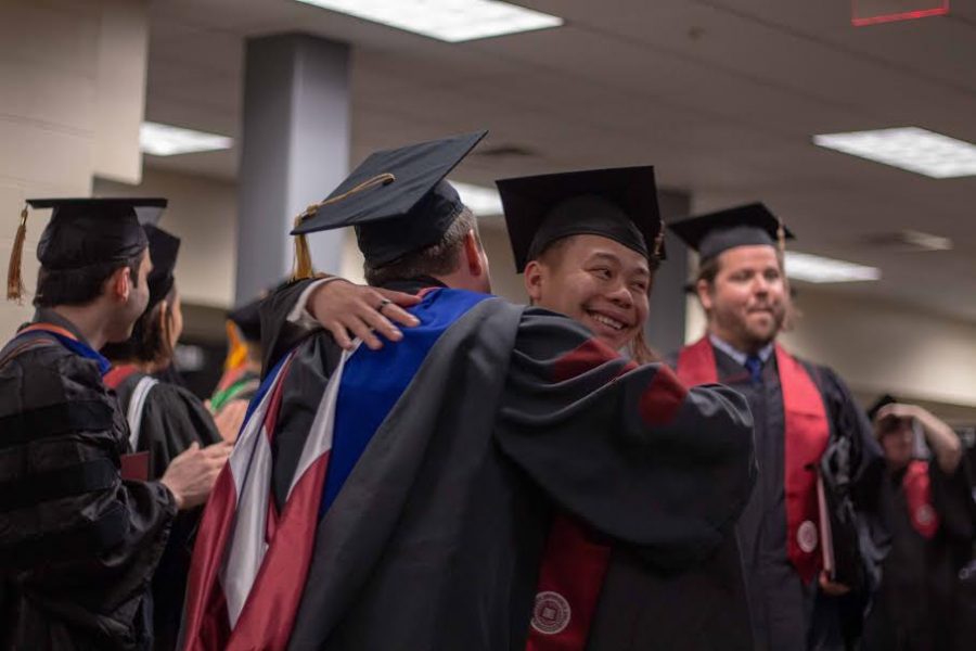 A student embraces a professor after receiving his diploma.