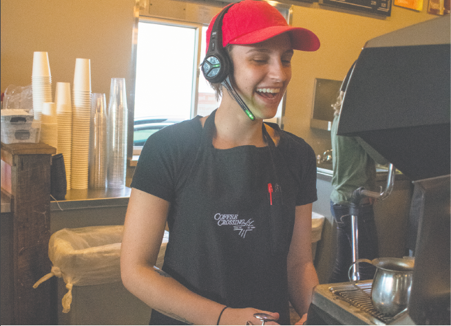 Alexis+Mattingly%2C+Coffee+Crossing+employee%2C+laughs+while+steaming+milk+for+a+customer.+Photo+by+Josie+Garwood