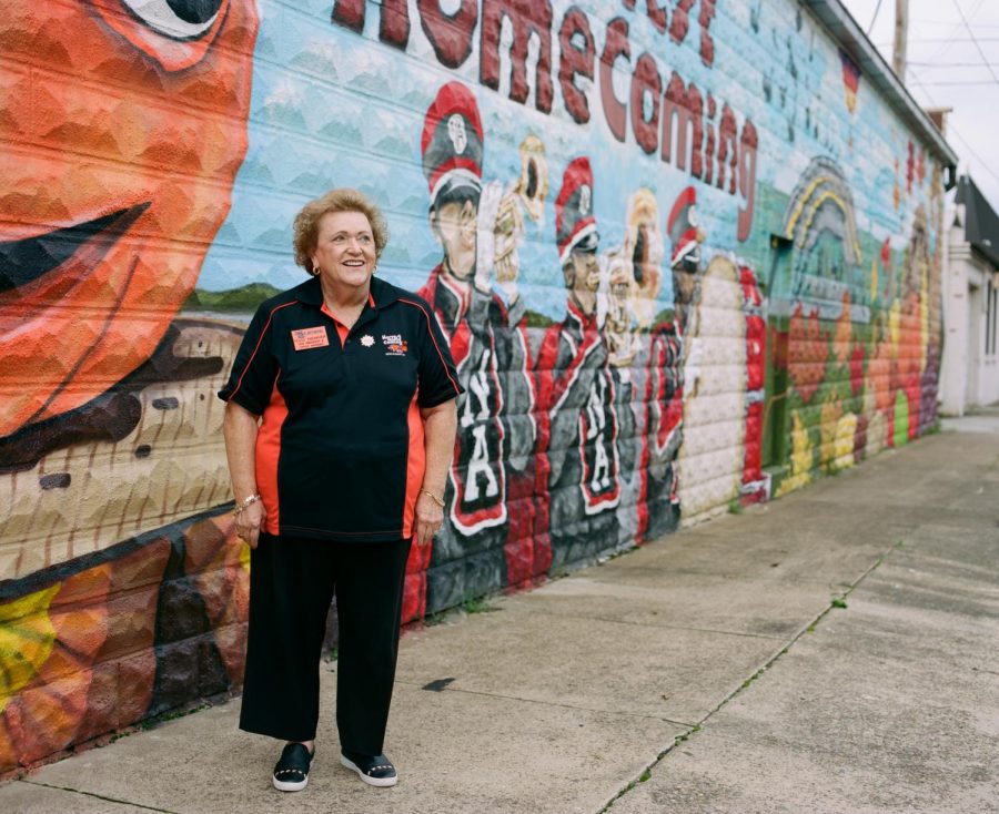 Polly Niemeier stands in front of a mural painted on the Harvest Homecoming office building.