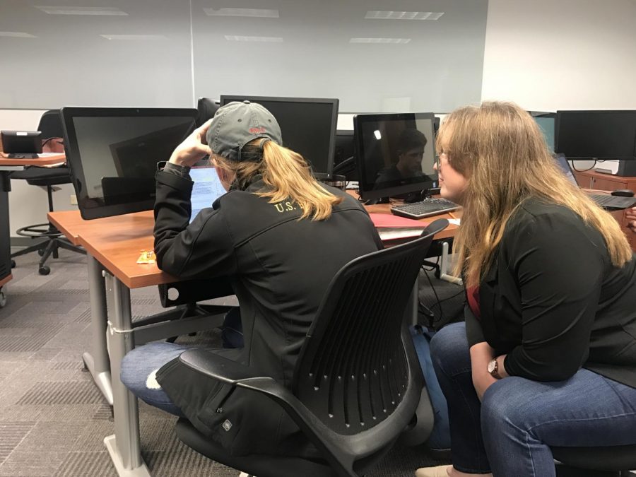 Sarah Caminiti, a business SI leader, assists Rachel Rozenboom, an international business sophomore, with an Access program project for Computer in Business.