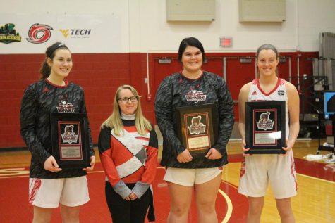 (From left to right) Baylee Kreuger, IUS Pep Band senior Kristina Peter, Kelsi Scott, and Josie Hockman pose for pictures prior to the Grenadiers' game versus Brescia. Photo by Brandon Miniard