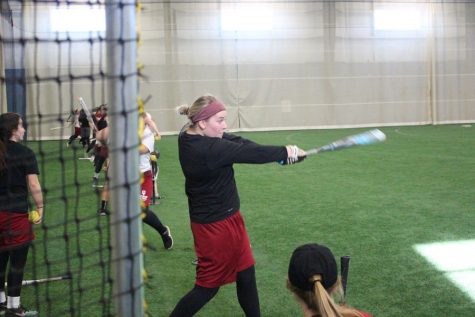 Sydney Seger hits off a tee during batting practice at the Silver Street Park indoor facility in New Albany.