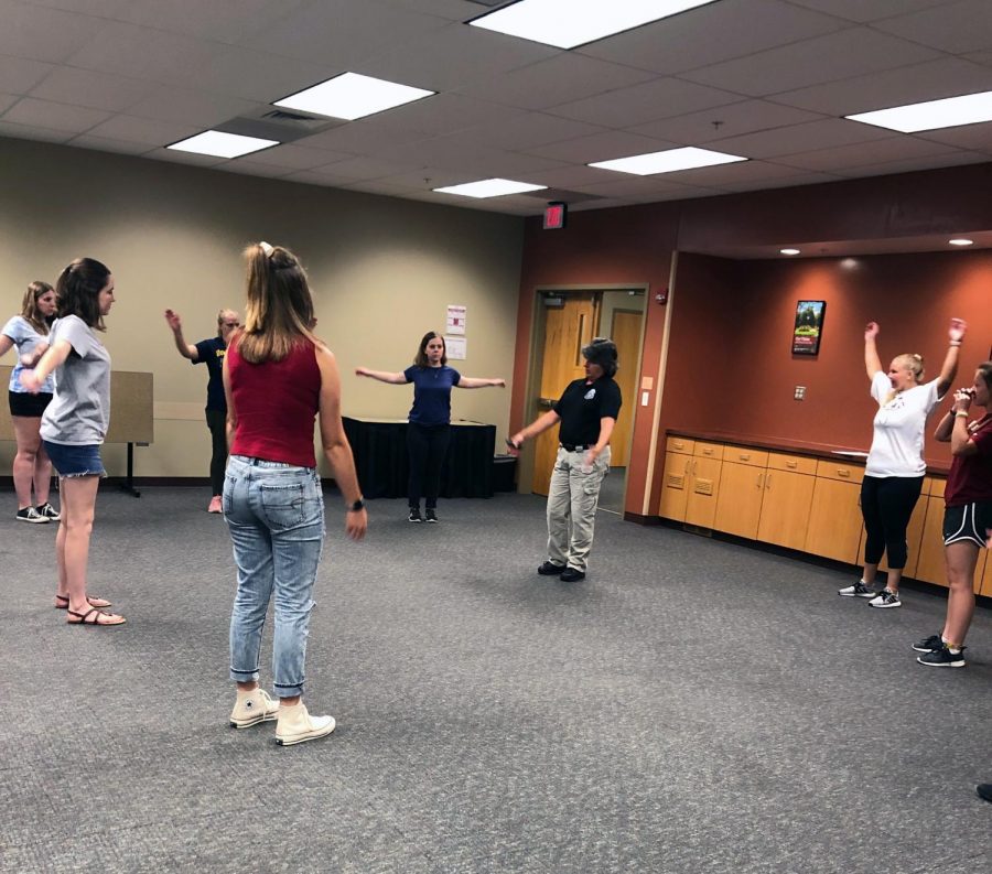 Monica Burnell-Wise leads off exercises to get students warmed up for the physical portion of the women’s self-defense class.
