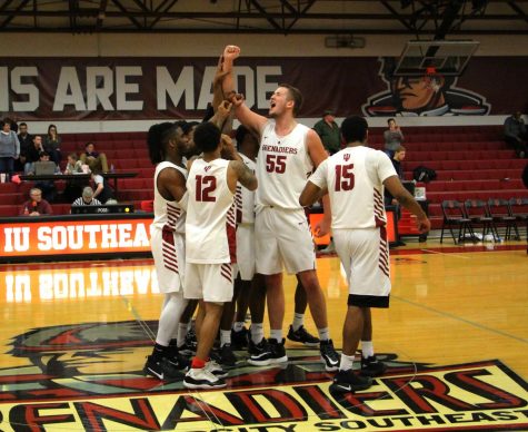 The Grenadiers huddle around senior center Seth Cox after their RSC West clenching victory over IU Kokomo.