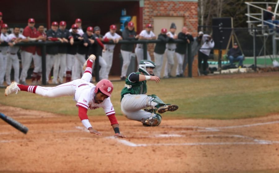 Santrel Farmer slides past home plate after colliding with Huntington catcher Eli Knust during a doubleheader on Feb. 27.