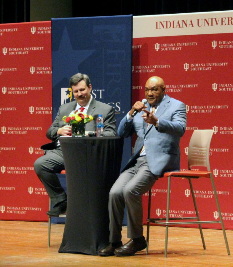 Dr. David Eplion, the dean of the school of business, left, and George
Foreman, two-time heavyweight champion boxer and businessman, right,
take questions from cards from the audience for Foreman to answer.