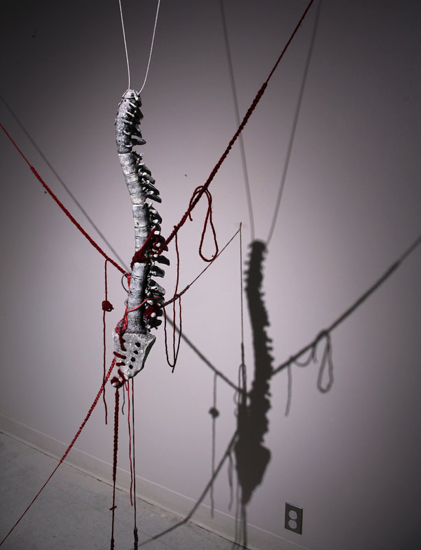 Artwork showcased at the event by Riegger. They describe this piece as ​This installation is a body narrative piece of a burdened back with knots, tightness, and a history of labor-intensive activity. 
